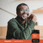 A middle-aged Black man smiling, resting his chin on his hand, next to a jar of Pumpkin Seed Oil with Saw Palmetto.