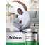 Young Black male stretches on yoga mat with Horbäach White Willow Bark bottle beside him.