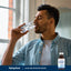 A man drinks water enhanced with Alkaline Booster Drops.