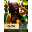 Lifestyle image of smiling woman with long braided hair, Jamaican Black Castor Oil bottle, and graphic stating GLOW.