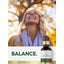 Lifestyle image of smiling woman outdoors with Carlyle Liquid Sea Moss bottle and graphic stating BALANCE.