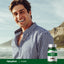 A smiling man outdoors holds a Cloves bottle, capturing a lifestyle moment.