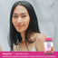 A young woman smiles beside a bottle of Hair, Skin & Nails Gummies, promoting beauty and wellness.