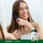 A young woman combs her hair with a Horsetail supplement bottle beside her.