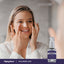 Woman applying serum to her face next to a Hyaluronic Acid Serum bottle.