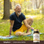 Mature man smiling while relaxing on a yoga mat outdoors next to a bottle of Korean Panax Ginseng.