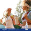 Two young women playing tennis with a Liquid B-12 Berry dropper bottle visible in the scene.