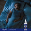 A young adult male sleeps in bed, with a bottle of Liquid Melatonin 10 MG beside him.