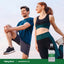 Man and woman stretching outdoors with a bottle of Magnesium Oil spray.