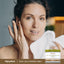 Young woman drying her face with a towel, next to a jar of Royal Jelly & Manuka Honey Cream visible on the counter.