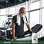 Adult smiling while standing on a treadmill at a gym, with a Piping Rock Organic Moringa Leaf Powder bottle nearby