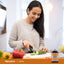 Adult smiling while slicing a cucumber on a cutting board, with a Nature's Treasure® Rutin 500 mg bottle nearby