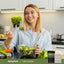 Lifestyle image of adult eating salad in kitchen with Piping Rock 3-Day Cleanse nearby