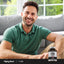 Adult smiling while seated indoors, with a Piping Rock Mega T1000 Standardized Tribulus Terrestris supplement bottle nearby