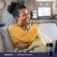 Smiling woman on a couch with a blanket next to a Magnesium Glycinate 750 mg 200 Capsules bottle.