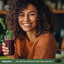 Young woman smiling with a smoothie beside a bottle of Resveratrol Berberine Grape Seed Quercetin Complex.