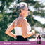 Lifestyle image of adult jogging outdoors with Piping Rock Organic Sambucus Elderberry bottle nearby