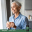 Adult holding a mug by a window with Piping Rock Adrenal Cortex supplement bottle nearby
