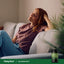 Lifestyle image: Woman relaxing on a couch with PipingRock Valerian Root supplement bottle nearby.