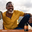 An older man smiling while sitting outdoors next to a Super Ceylon Cinnamon bottle.