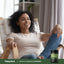 Woman relaxing in a chair with Piping Rock Sambucus Black Elderberry supplement bottle nearby