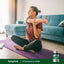 An adult woman stretches on a yoga mat with a Potassium Plus Iodine bottle next to her.