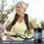 Middle-aged woman biking outdoors with a bottle of Strontium Citrate.