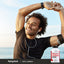 Active lifestyle image of an adult stretching outdoors while wearing earbuds, with a Piping Rock Multi Aminos 3000, 200 caplets bottle displayed nearby.