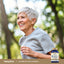 Adult smiling while walking outdoors, with a Piping Rock Complete B-Complex + Vitamin C bottle nearby