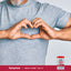 An older man forms a heart shape with his hands next to a CoQ-10 bottle.