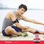 An Asian man stretches outdoors next to a bottle of CoQ-10 supplement.