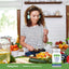 A young woman chops vegetables and listens to music next to a bottle of Probiotic Acidophilus.