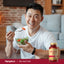 Middle-aged man enjoying a salad next to a bottle of Red Yeast Rice.