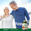 Middle-aged couple smiling, standing arm-in-arm outdoors with a bottle of Turmeric Curcumin beside them.