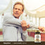 A man stretches his arm while holding a Super Ginseng Complex Plus Royal Jelly supplement bottle.
