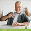 An older man smiling with a glass of water beside a Sweeter Stevia Liquid bottle.