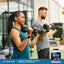 Woman and man exercising with dumbbells beside a WheyFit Protein container.