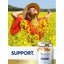 Young adult woman smiling in a field of yellow flowers with a Carlyle NAD+ Advanced Gummies bottle beside her enjoying the sun.